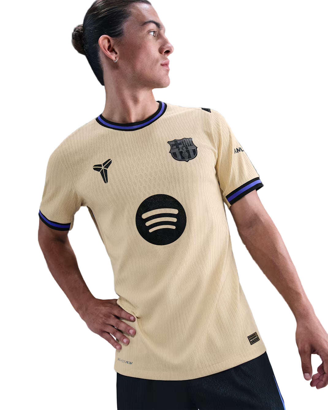 Person wearing a beige sports jersey with various logos on a gray background