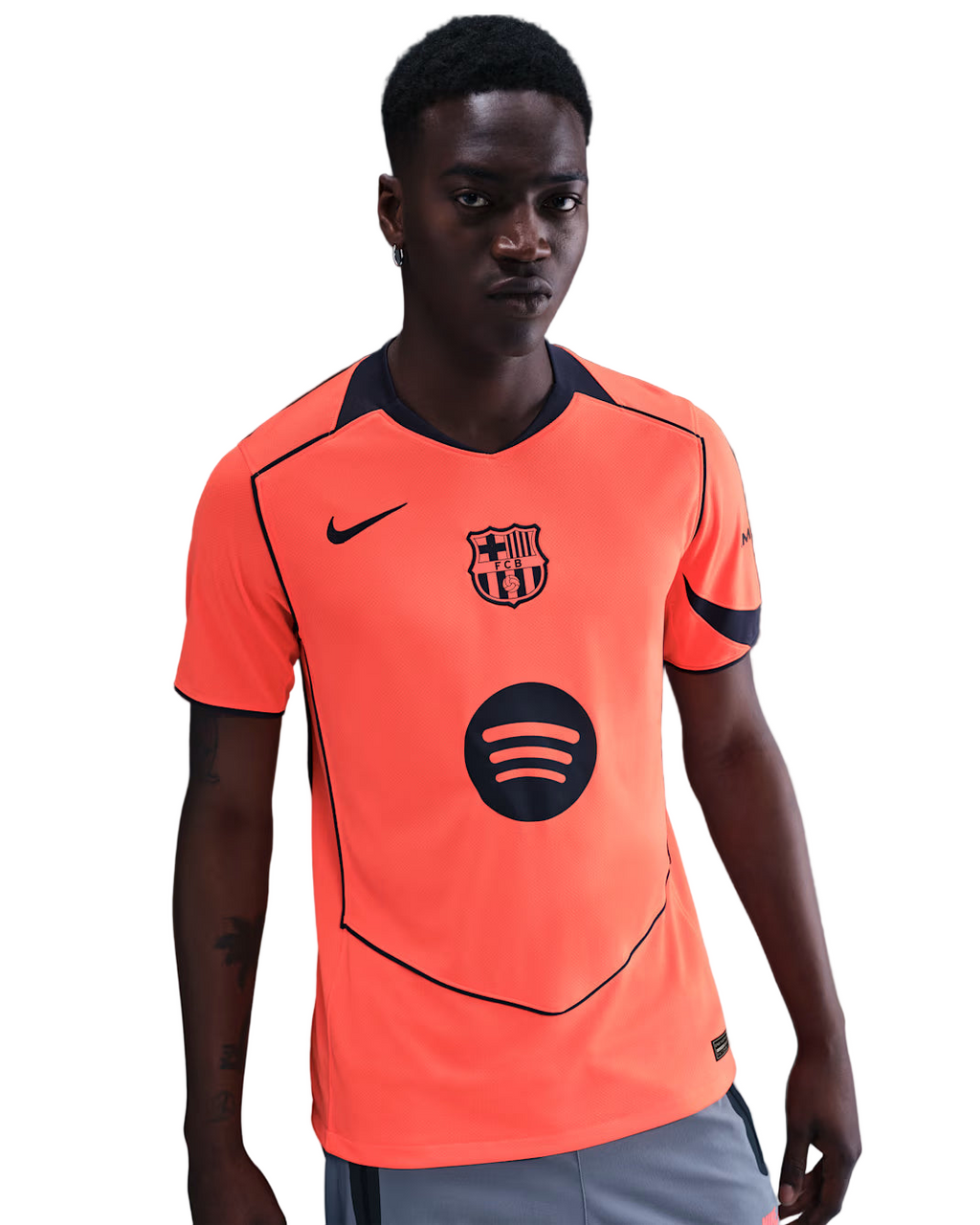Person wearing an orange sports jersey with a logo on a gray background
