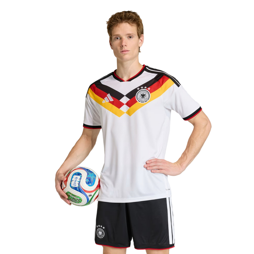 Person wearing a German soccer jersey holding a soccer ball on a white background