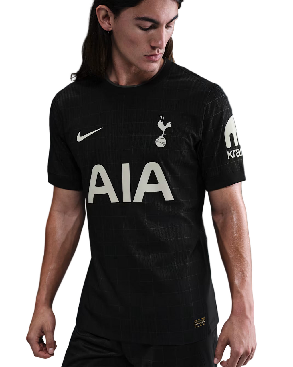 Person wearing a black sports jersey with visible branding on a dark background