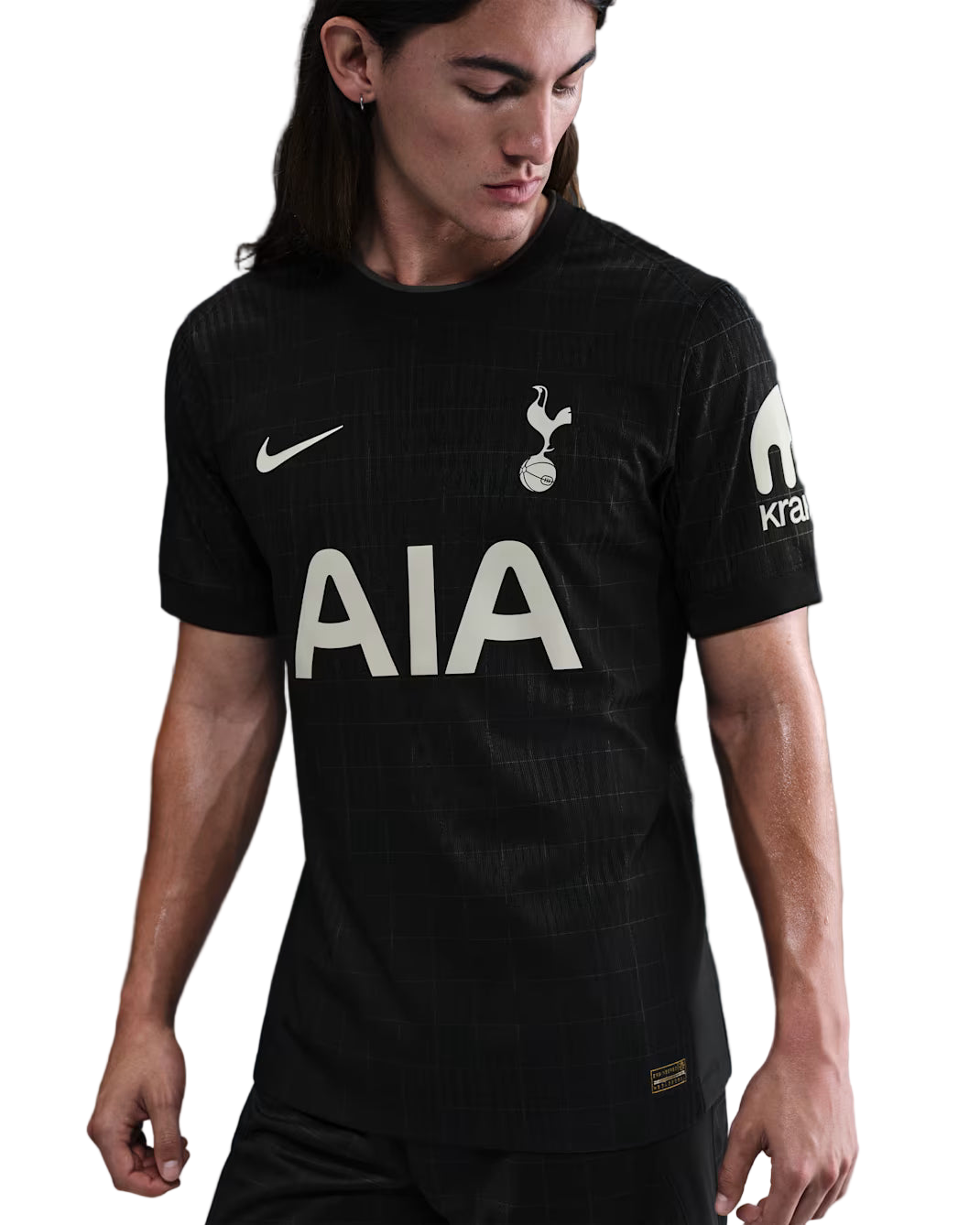 Person wearing a black sports jersey with visible branding on a dark background